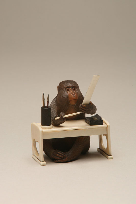 Monkey scholar seated at his desk writing a poem