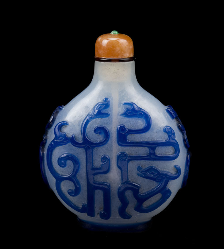 Overlay glass snuff bottle with blue confronting dragons on a camphor ground