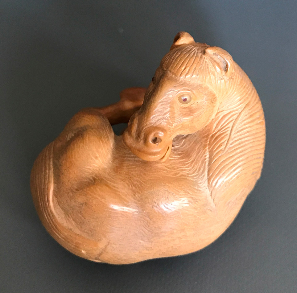 Boxwood netsuke of a rolling horse