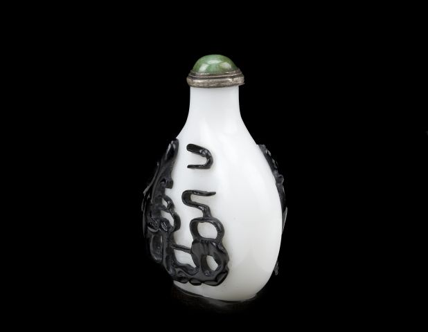 Overlay glass snuff bottle with black dog on one side and an eagle on the reverse
